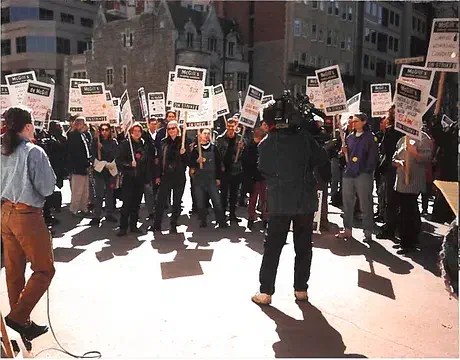 Picketers around a person with a microphone.