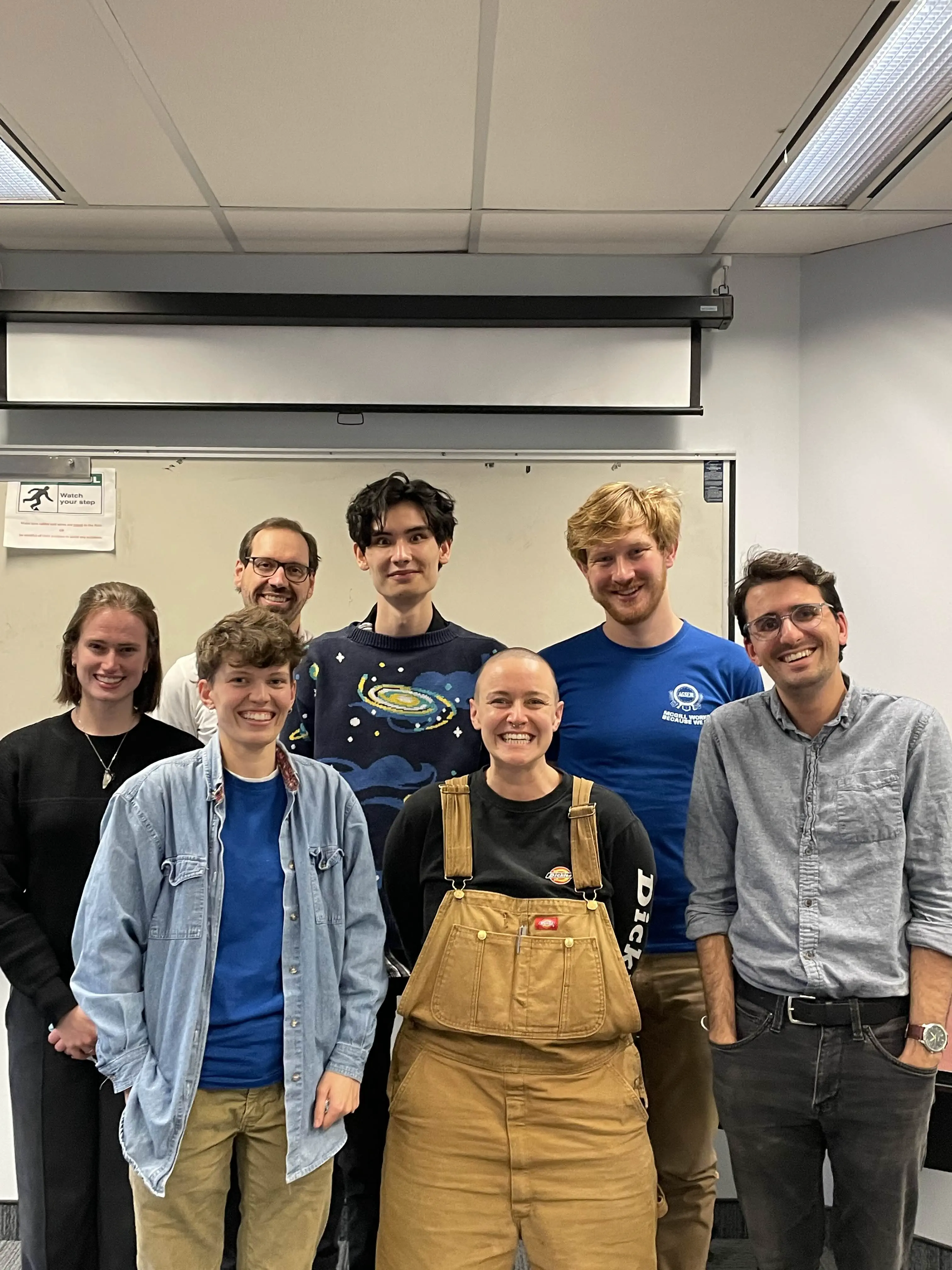 Membres de votre équipe de négociation du 7 novembre, après la séance. un groupe de sept personnes dans une salle de classe, souriant à la caméra.